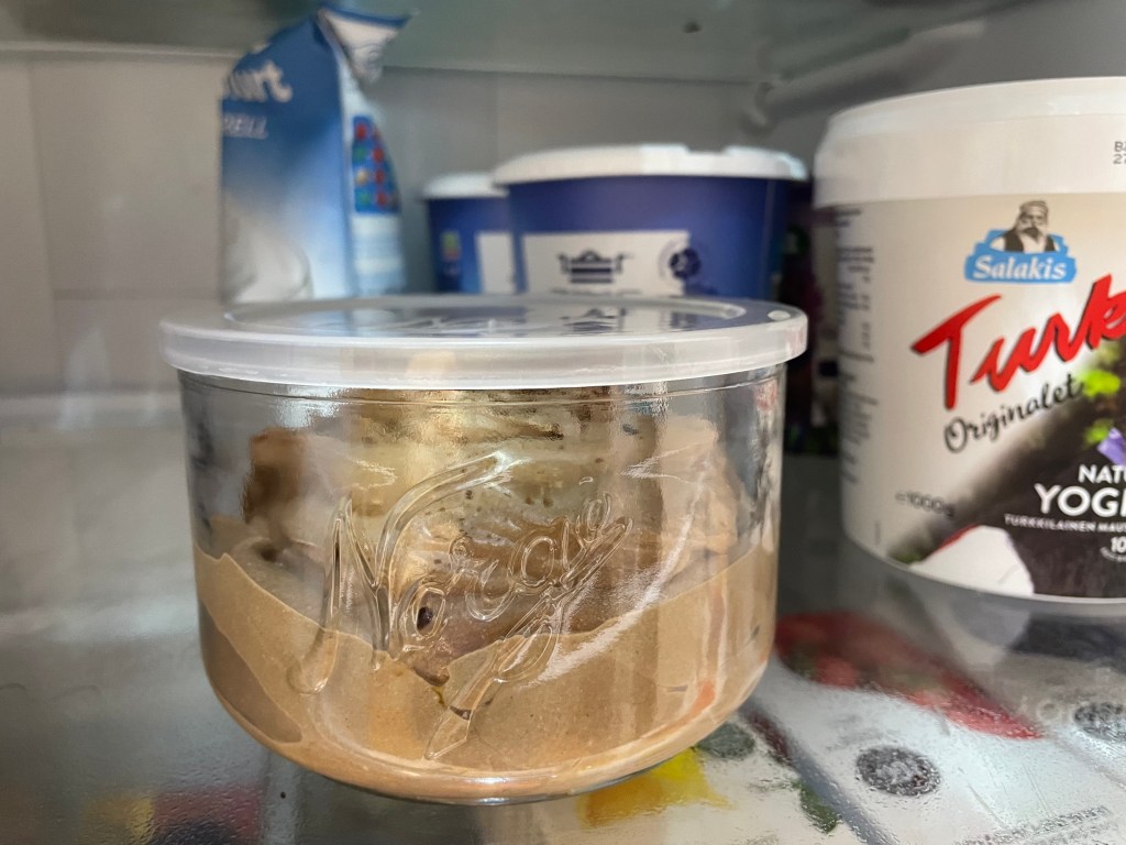 Nærbilde av glassbolle med sjokoladeproteinpudding i et kjøleskap